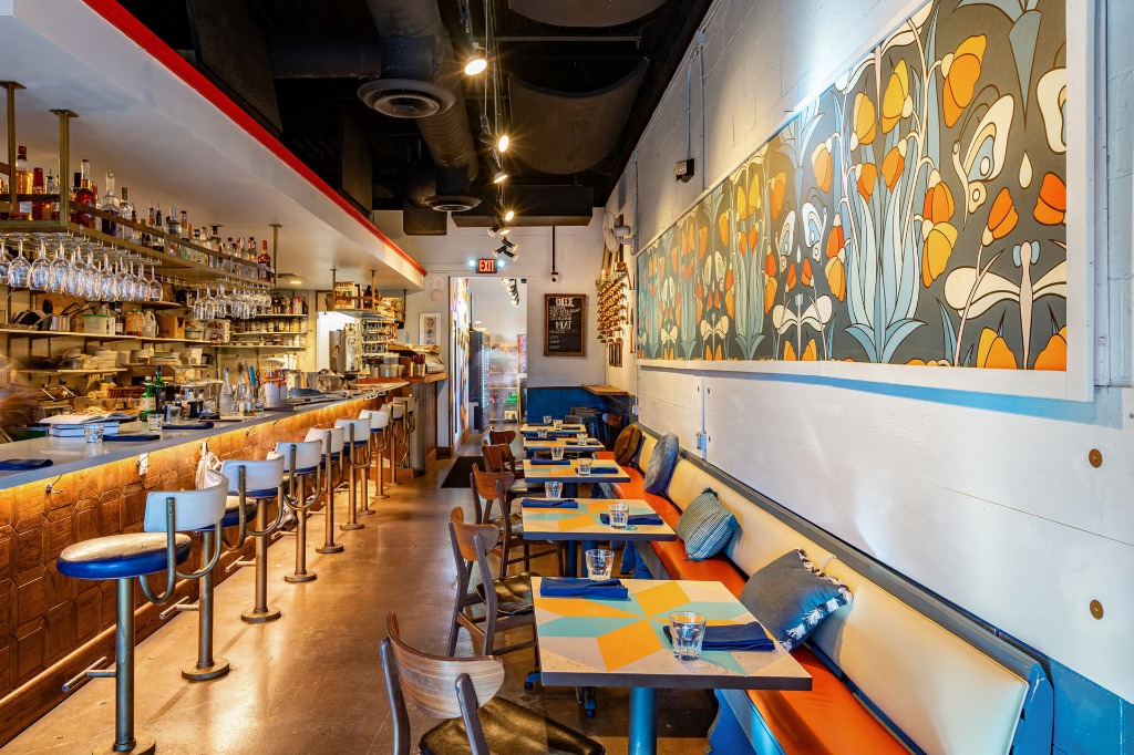 Interior of The Downing Bottles and Bites featuring a beautiful floral mural and retro bar seating